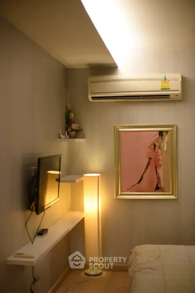 Cozy bedroom with modern decor, featuring air conditioning and stylish wall art.