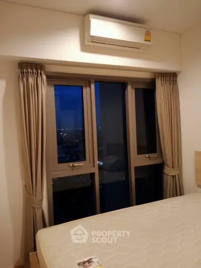 Cozy bedroom with city view and air conditioning in modern apartment