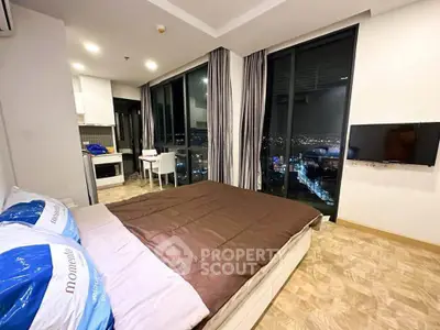 Modern bedroom with city view, featuring large windows and stylish decor.