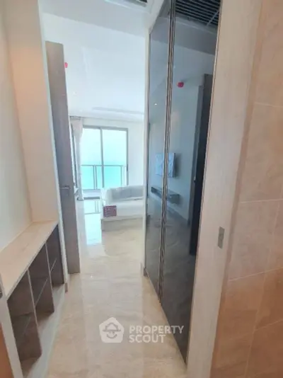 Spacious and well-lit bedroom with a large mirrored wardrobe reflecting a serene living area, leading to a balcony with a view, perfect for modern living.