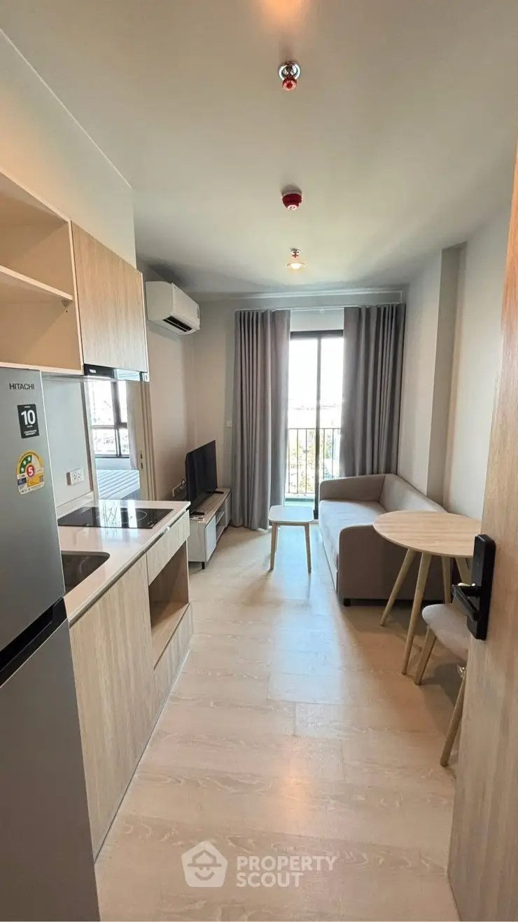 Modern compact living room with open kitchen and balcony view