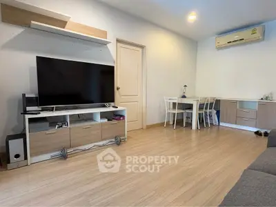 Modern living room with sleek furniture and large TV, perfect for relaxation and entertainment.