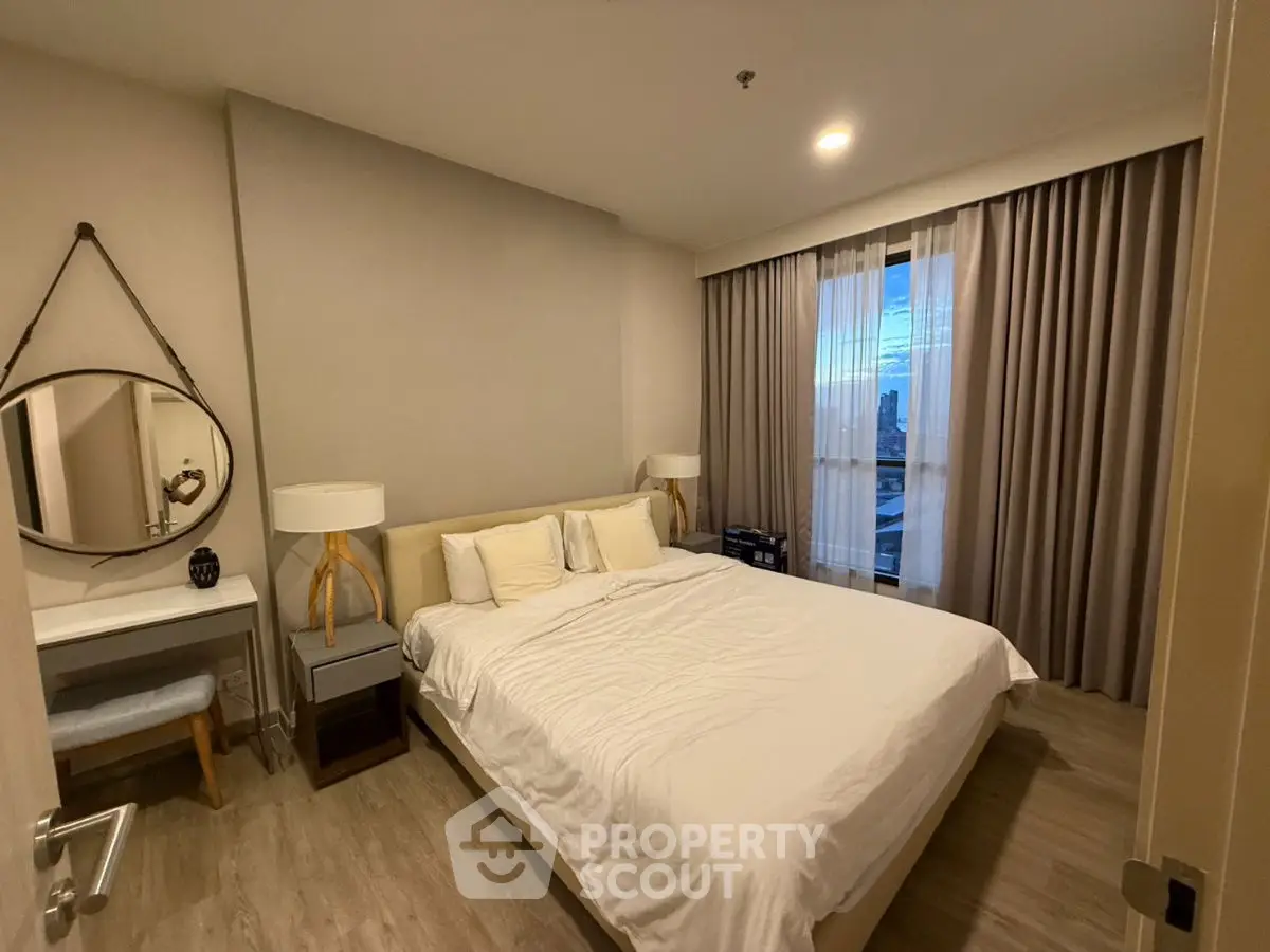 Cozy bedroom with modern decor and large window offering city view