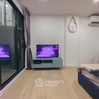 Modern living room with sleek TV setup and large window, showcasing minimalist design.