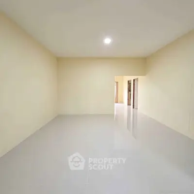 Spacious empty room with glossy tiled flooring and neutral walls, ideal for customization.