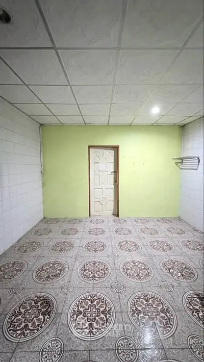 Spacious room with decorative tiled flooring and green accent wall, ideal for versatile use.