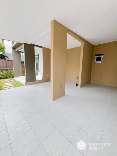 Spacious modern patio with tiled flooring and open layout, perfect for outdoor gatherings and relaxation.