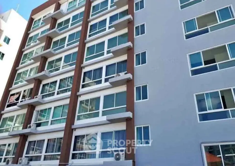 Modern multi-story apartment building with large windows and balconies.