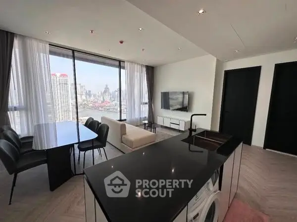Modern living room with city view, sleek furniture, and integrated kitchen appliances.