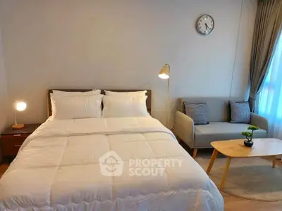 Cozy bedroom with modern decor, featuring a comfortable bed, stylish sofa, and elegant lighting.