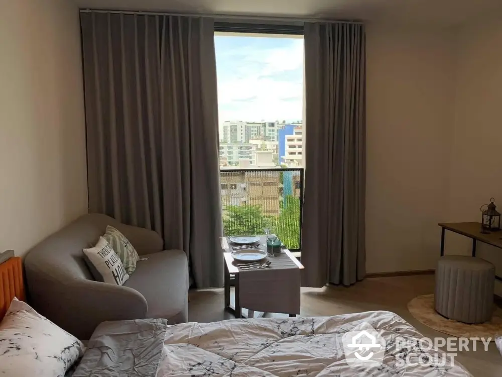 Cozy bedroom with city view, featuring a comfortable bed and stylish decor.