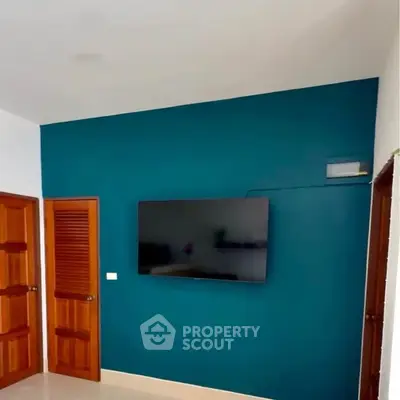 Modern living room with wall-mounted TV and wooden doors