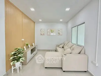 Modern living room with beige sectional sofa and stylish decor in a bright, minimalist space.