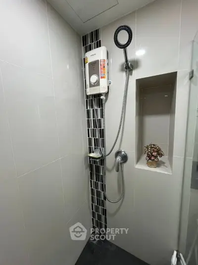 Modern bathroom with sleek shower design and built-in shelf, perfect for contemporary living.