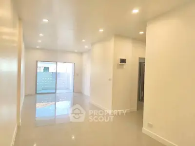 Spacious modern living room with bright lighting and sliding glass doors.