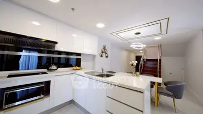 Modern kitchen with sleek white cabinetry and integrated appliances in a stylish open layout.