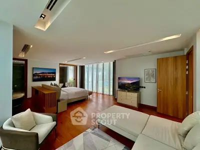 Luxurious and spacious bedroom with modern decor and large windows offering natural light.