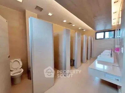 Spacious modern public restroom with multiple stalls and sinks