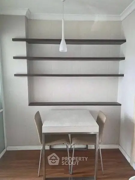 Modern dining area with sleek table, chairs, and minimalist shelving.