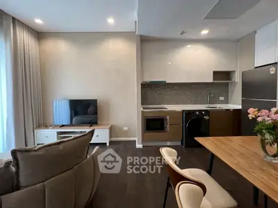 Modern open-layout living room and kitchen with stylish decor and appliances.