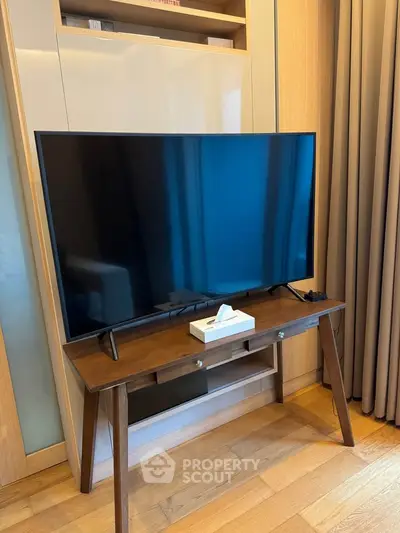 Modern living room with sleek TV on wooden stand and elegant curtains, perfect for cozy entertainment.