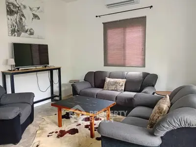 Cozy living room with plush sofas, modern TV setup, and stylish decor for ultimate comfort.