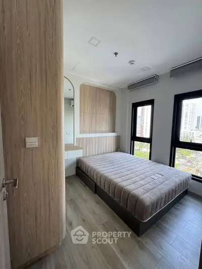 Modern bedroom with large windows and city view, featuring stylish wood paneling and minimalist design.