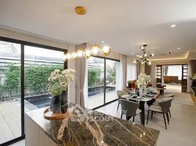 Luxurious open-plan living and dining area with elegant decor and pool view.