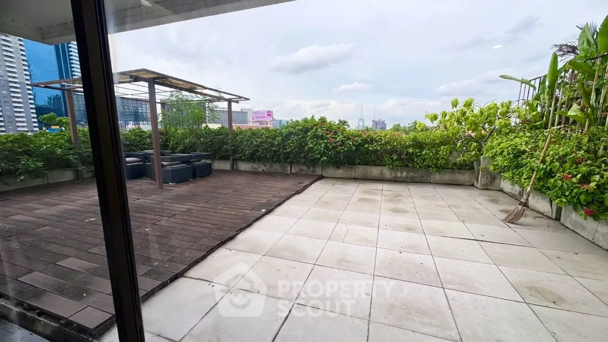 Spacious rooftop terrace with city views and lush greenery, perfect for outdoor relaxation and entertainment.
