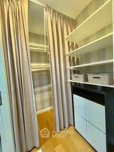 Spacious walk-in closet with ample shelving and elegant curtains in modern home.
