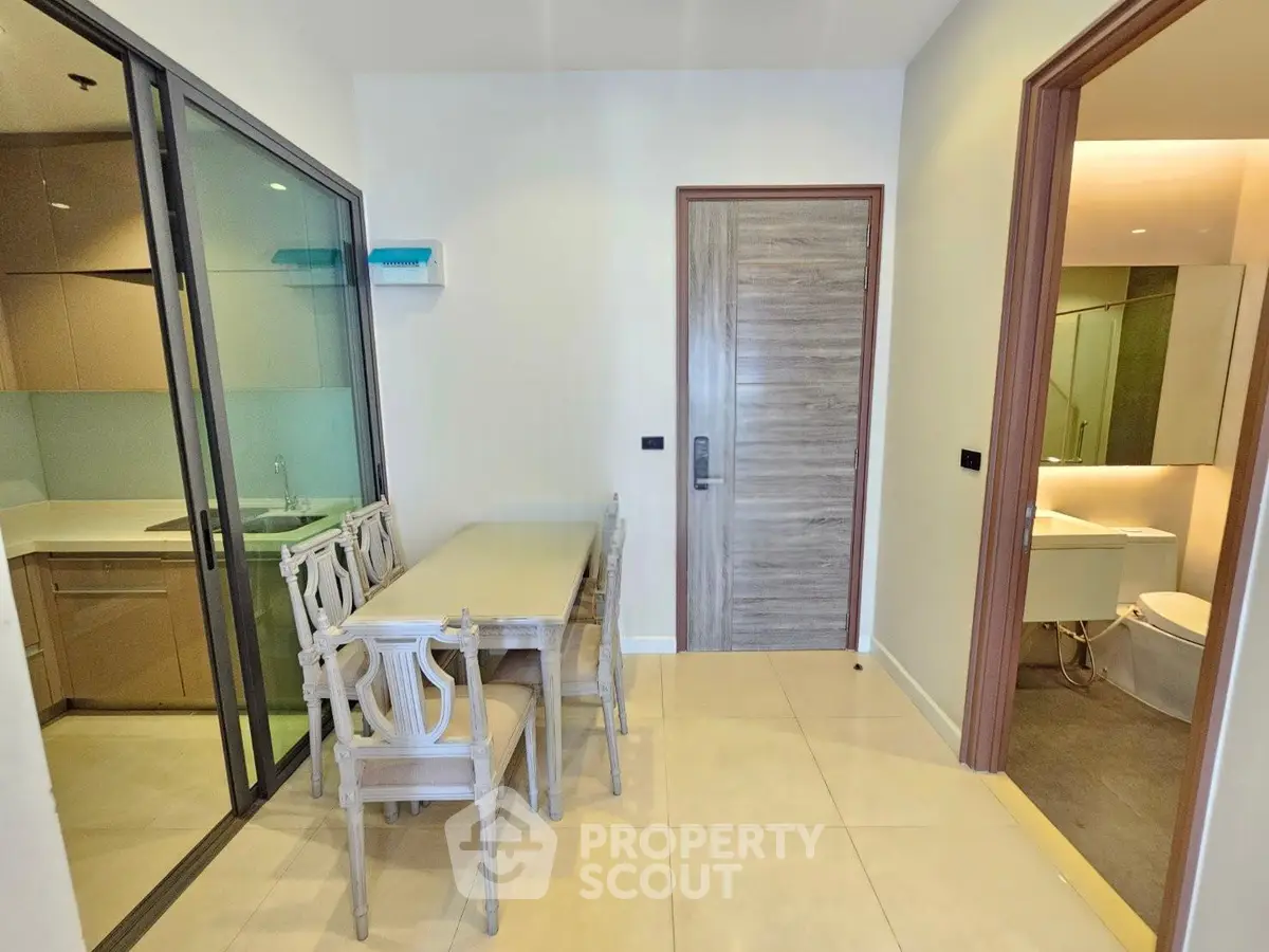 Modern apartment interior with dining area and view into kitchen and bathroom