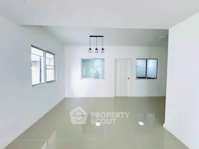 Spacious modern interior with sleek tile flooring and ample natural light.