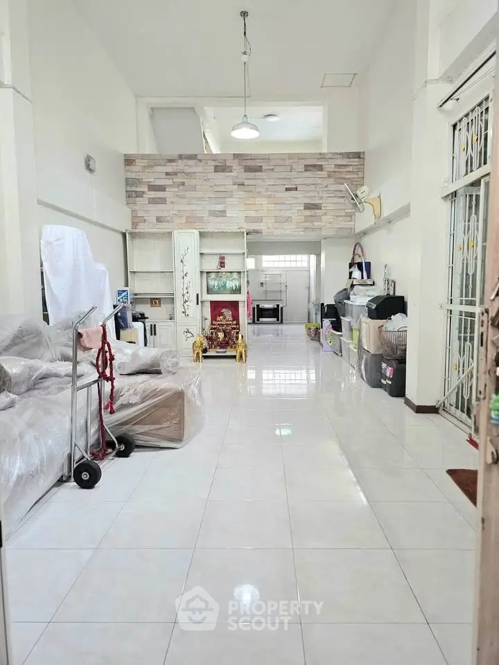 Spacious living room with high ceilings and tiled flooring, featuring a modern open layout and ample natural light.