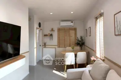 Cozy living room with modern decor, featuring a comfortable sofa, dining area, and large window for natural light.