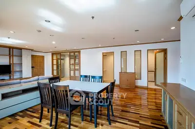Spacious open-plan living and dining area with wooden flooring and modern furnishings.
