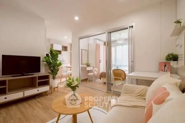 Modern living room with cozy decor and open layout leading to a bright study area.