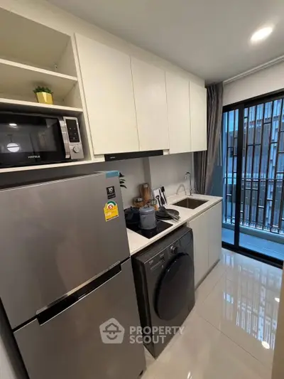 Modern kitchen with sleek appliances and balcony view