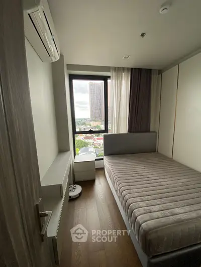 Cozy bedroom with city view, featuring a comfortable bed and modern air conditioning.
