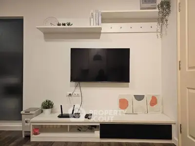 Modern living room with wall-mounted TV and sleek white shelving unit.