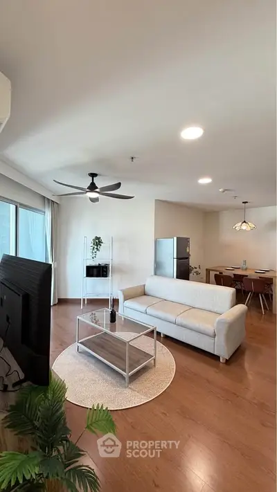 Spacious modern living room with elegant decor and open layout, featuring a cozy sofa and stylish dining area.
