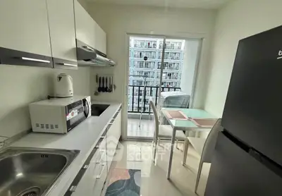 Modern kitchen with sleek appliances and balcony view in urban apartment