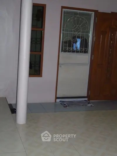 Spacious room with patterned floor tiles and large window, ideal for customization.