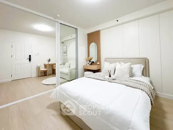 Modern bedroom with elegant decor and sliding glass doors leading to a cozy sitting area.