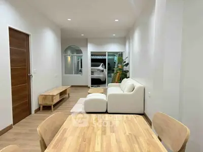 Modern living room with wooden furniture and cozy white sofa, perfect for relaxation and gatherings.