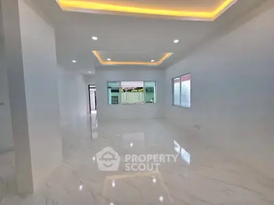 Spacious modern living room with elegant lighting and glossy marble floors.