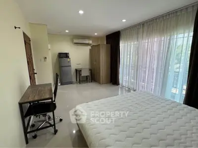 Spacious bedroom with large windows and modern furnishings, ideal for comfort and relaxation.