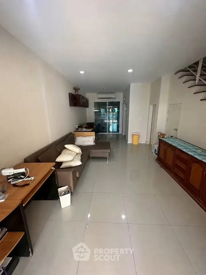 Spacious living room with modern furniture and sleek tile flooring in a contemporary home.