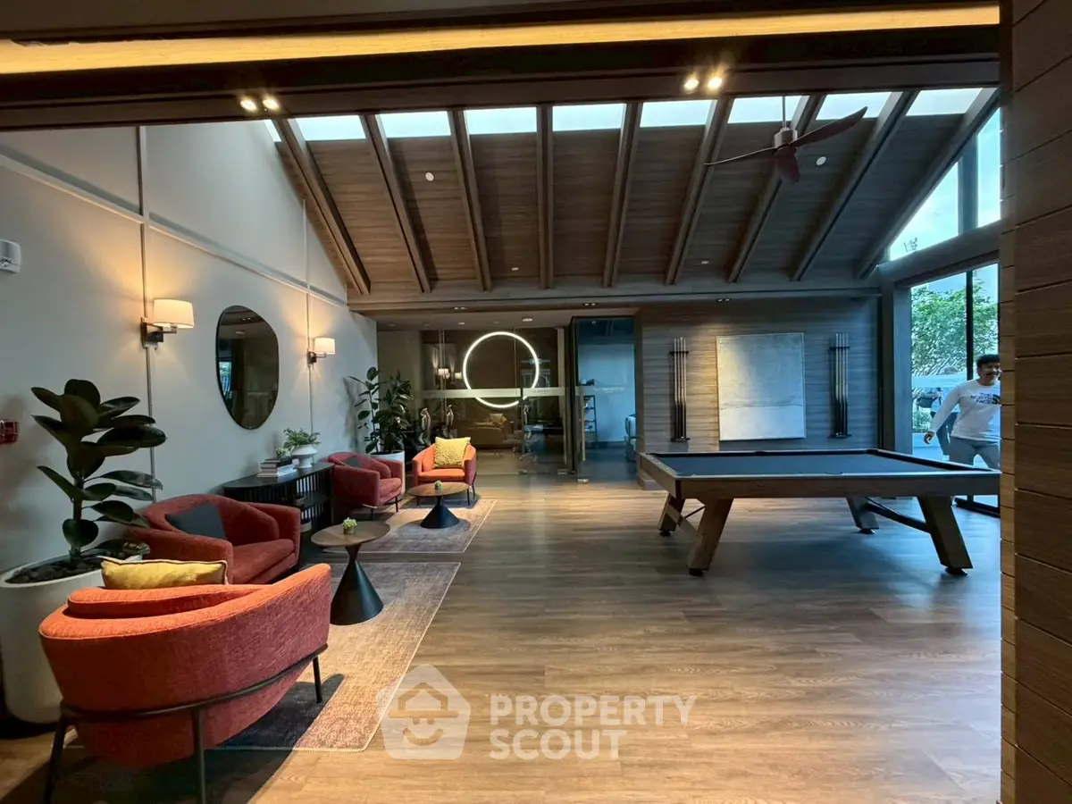 Luxurious living room with modern decor and pool table, perfect for entertainment.