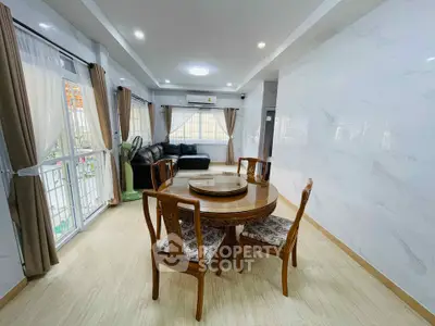 Spacious living room with elegant dining area and large windows
