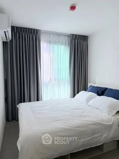 Modern bedroom with large window and elegant curtains in a stylish apartment.